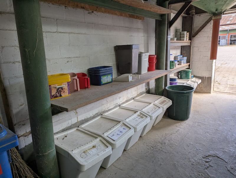 Futtertisch mit Eimern und Boxen für individuelle Pferdefütterung in der Futterkammer Gut Tangstedt